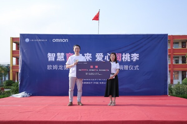 欧姆龙常务副总经理东谷隆史与小侯人民日报希望小学校长赵冬梅在捐赠仪式合影